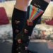 knee-high, black socks with books on them and say "Talk Wordy to Me"