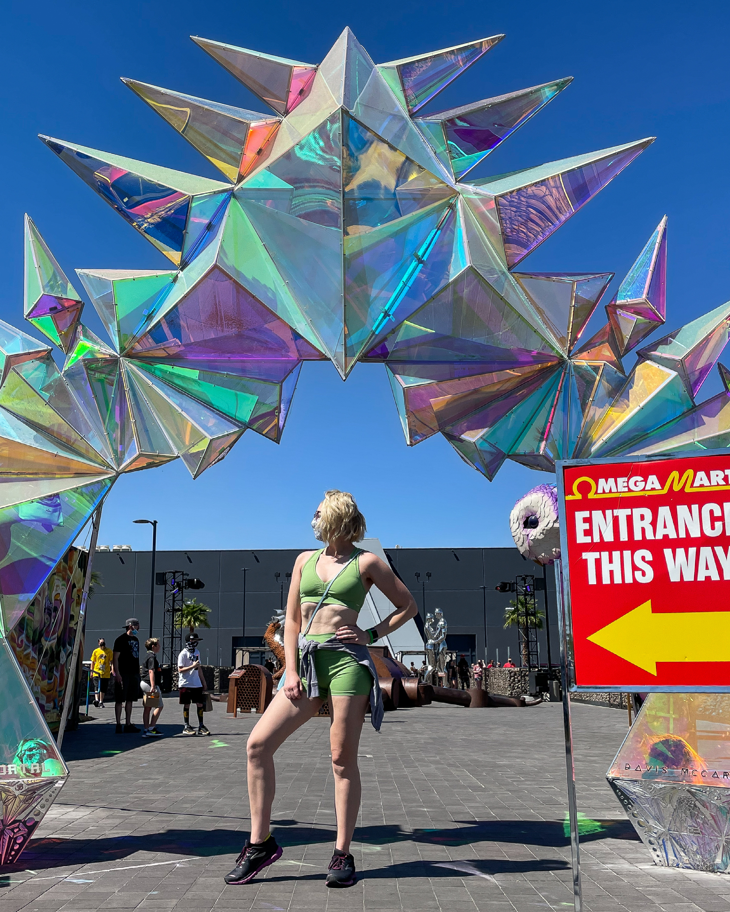 entrance to area 15 in Vegas, blonde girl in a green workout set standing in front of a luminous archway