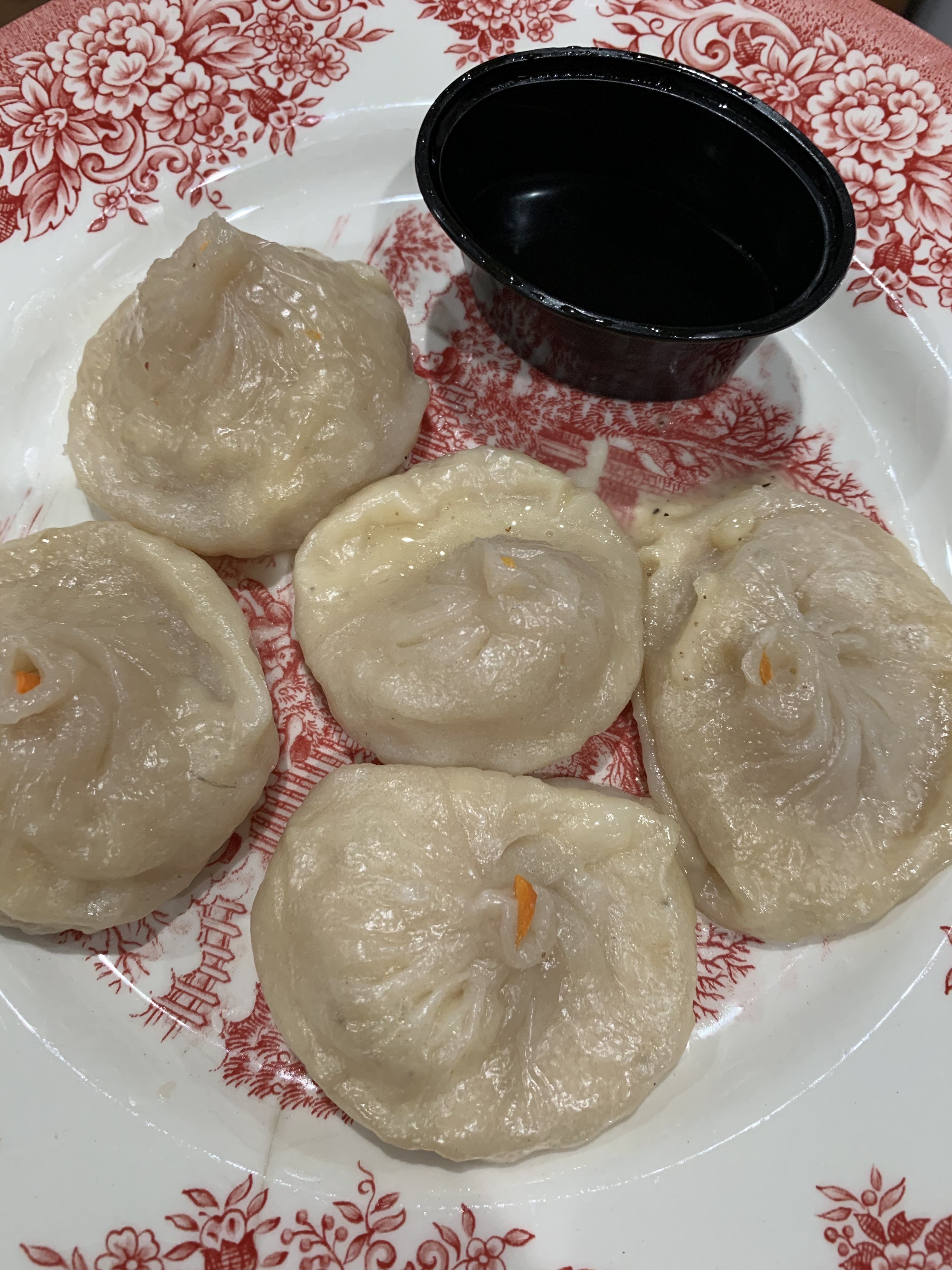 French onion soup dumplings with dipping sauce on a red and white patterned plate