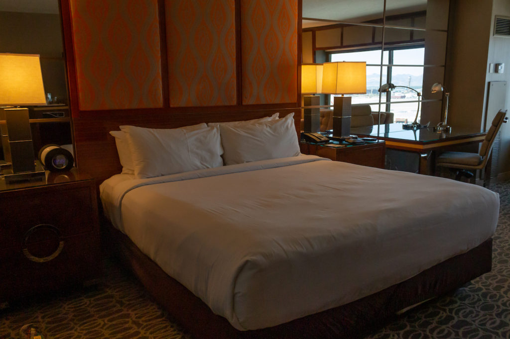 Interior suite at MGM Grand Las Vegas, white bedding, King-sized bed, gold colored lamps on the bedside tables