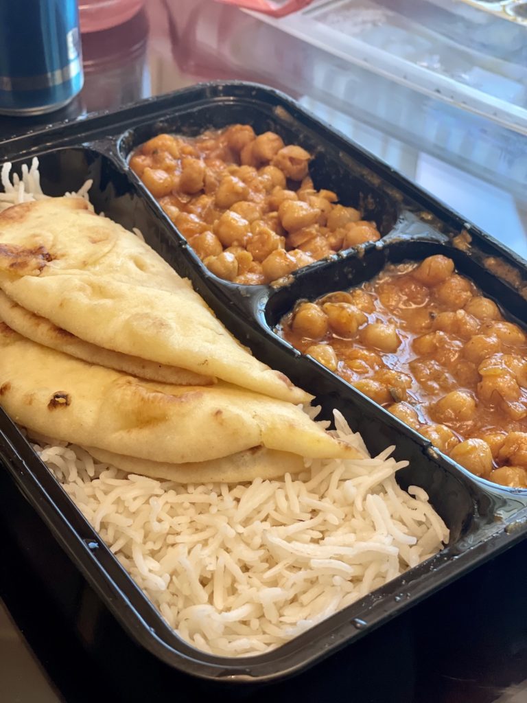 black To-Go container with a large portion of rice and Naan and two smaller portions filled with chana masala from Curry Pot Las Vegas
