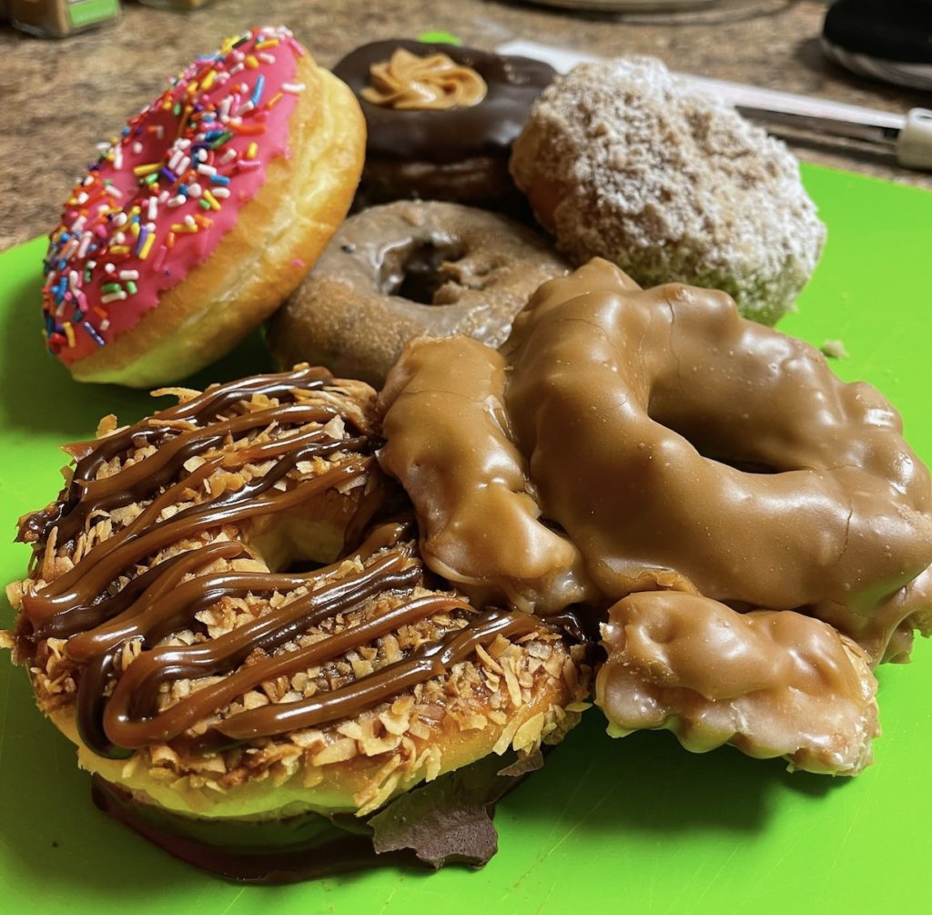 6 gourmet donuts on a bright green cutting board