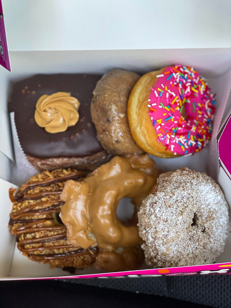 Pinkbox Donuts in Vegas, a pink box filled with six gourmet donuts of varying colors and flavors