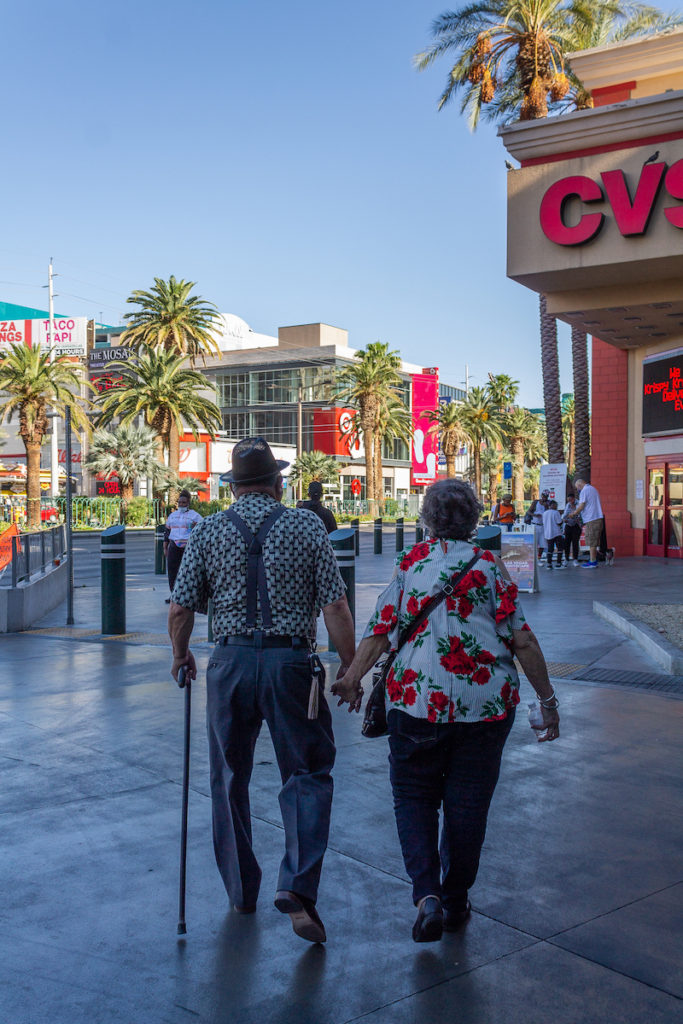 sweet older couple walking down the strip in Vegas and holding hands, middle of the day and sunny outside